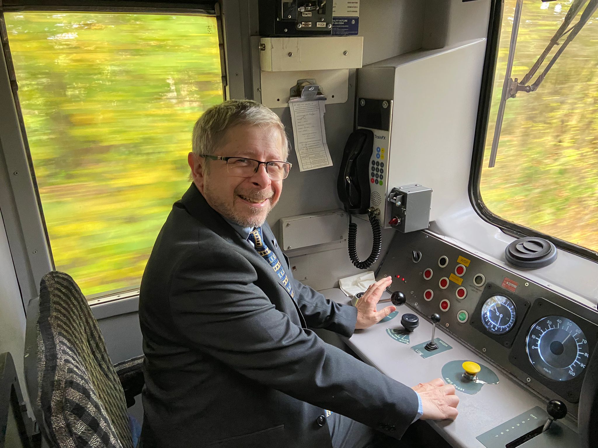 A train driver smiling as the greenery of West Devon rushes by